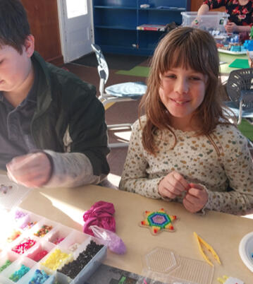 Playing with melty beads at a Holiday programme
